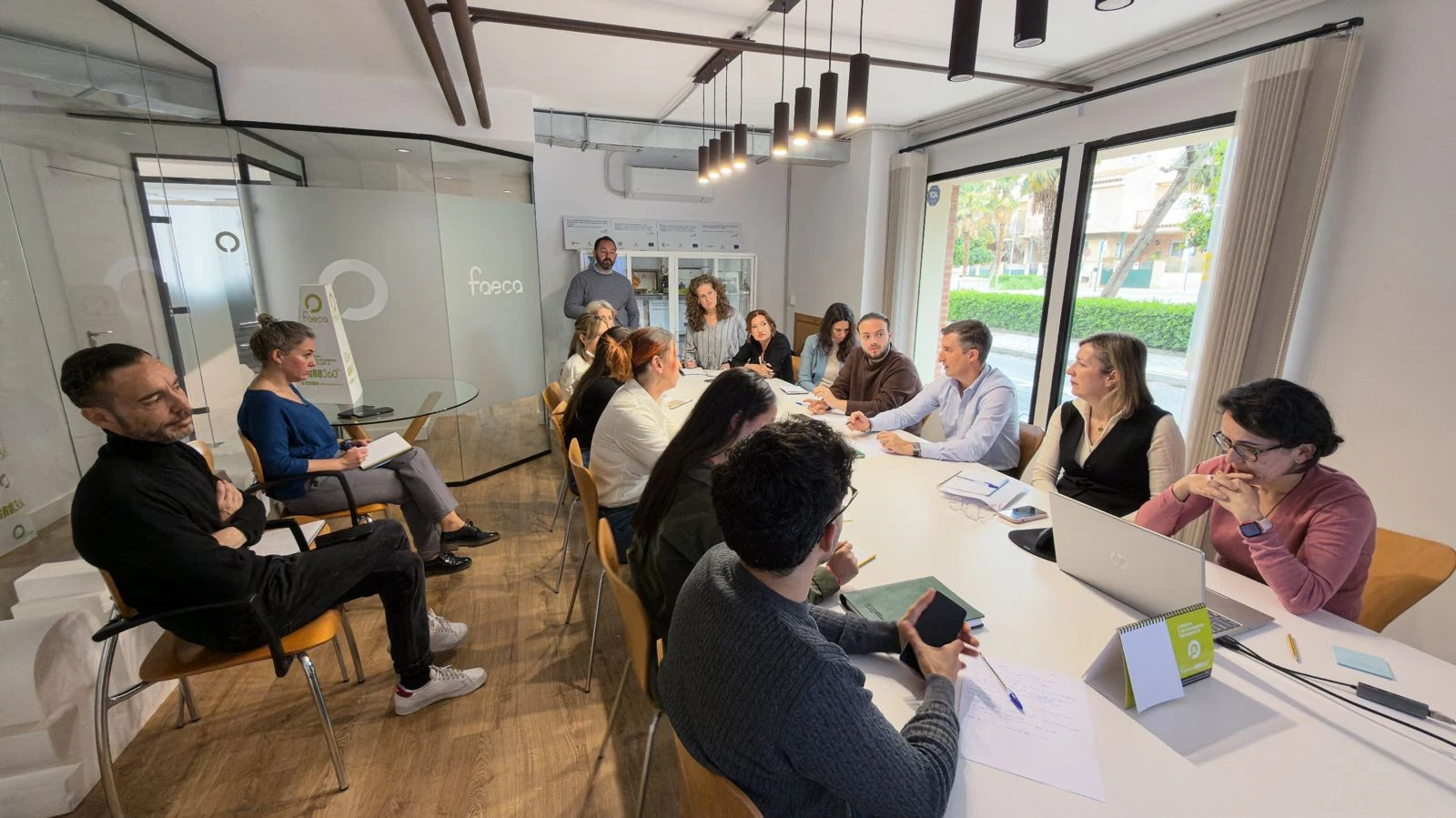 Equipo técnico de FAECA trabajando reunido alrededor de una mesa en sus oficinas para planificar el sistema de tramitación de ayudas a agricultores.